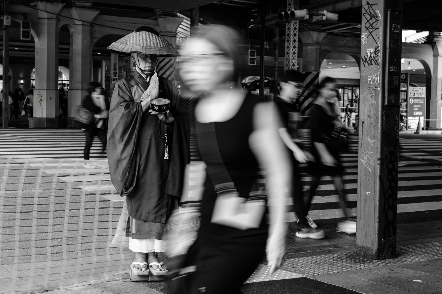 Slow-shutter street photography techniques in Ueno of a monk in prayer