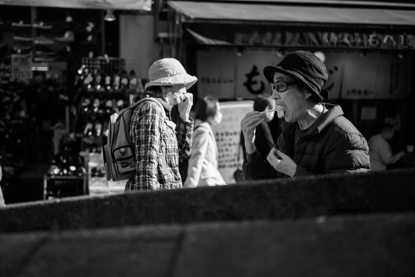 old lady eats in Ueno market-Gritty street photography Tokyo 2026