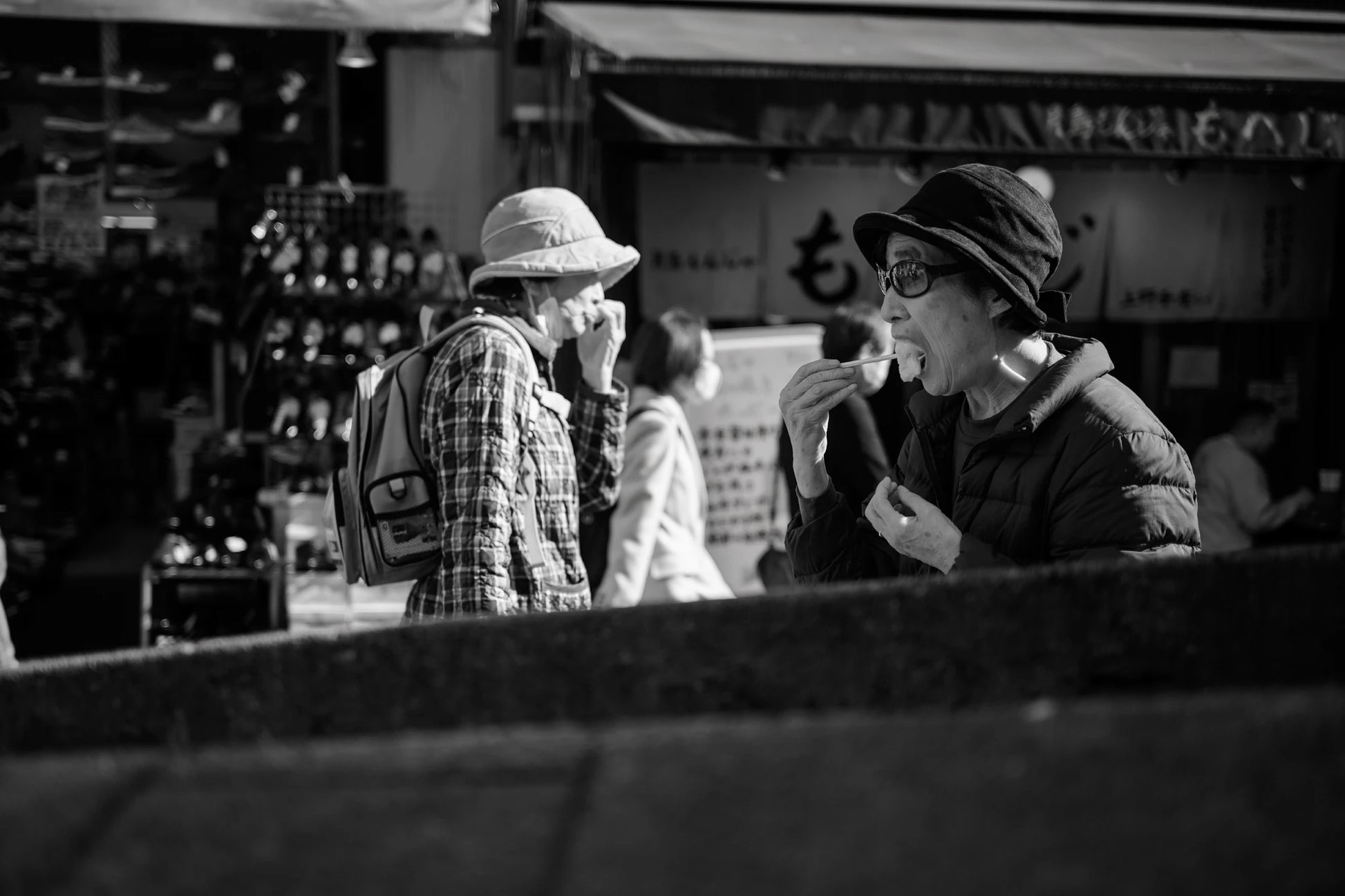 old lady eats in Ueno market-Gritty street photography Tokyo 2026