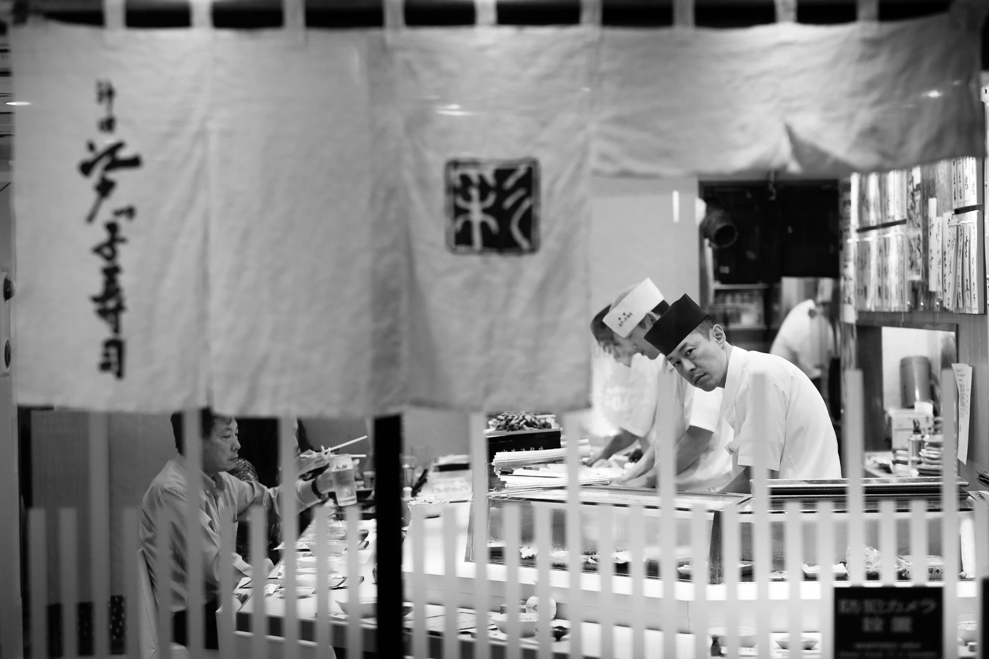 The "Decisive Moment" in Japan, a sushi chef looks up from his work.
