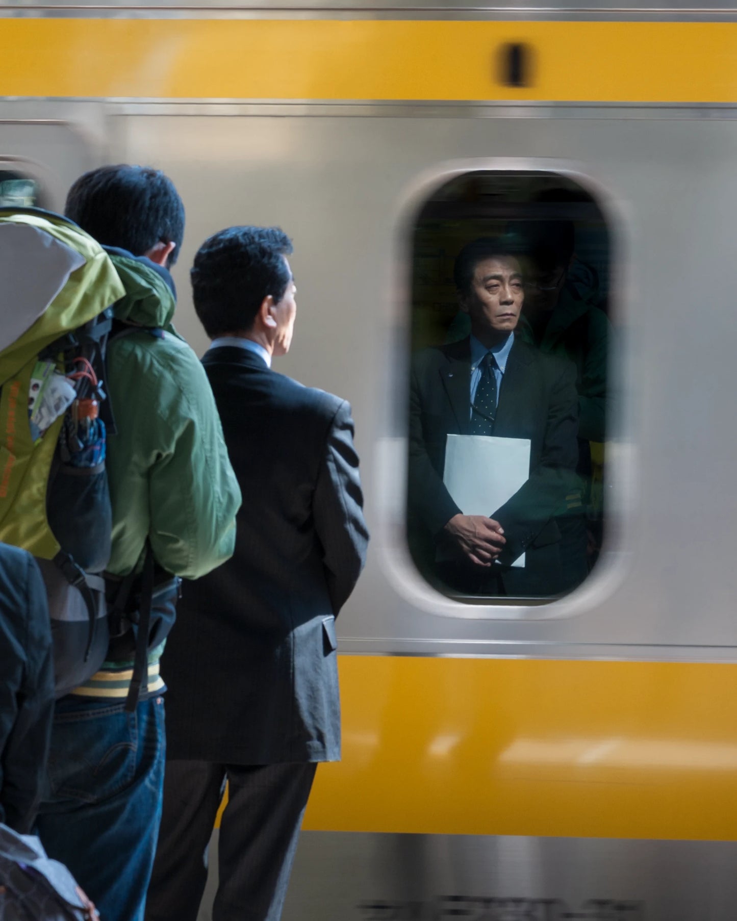 Japanese salaryman's reflection in Akihabara Sobu Line train-Cinematic street photography Tokyo