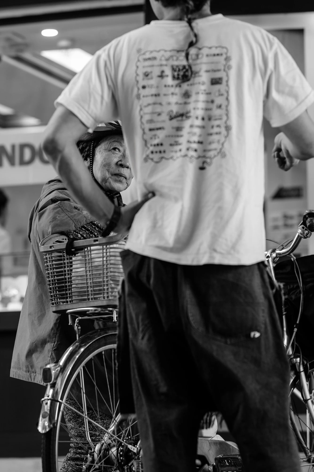 Candid street portraiture of an old lady listening in Ueno.