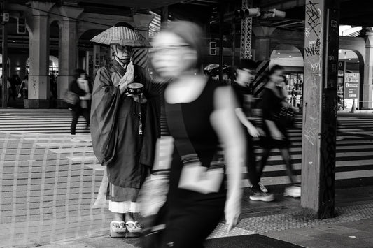 Slow-shutter street photography techniques in Ueno of a monk in prayer